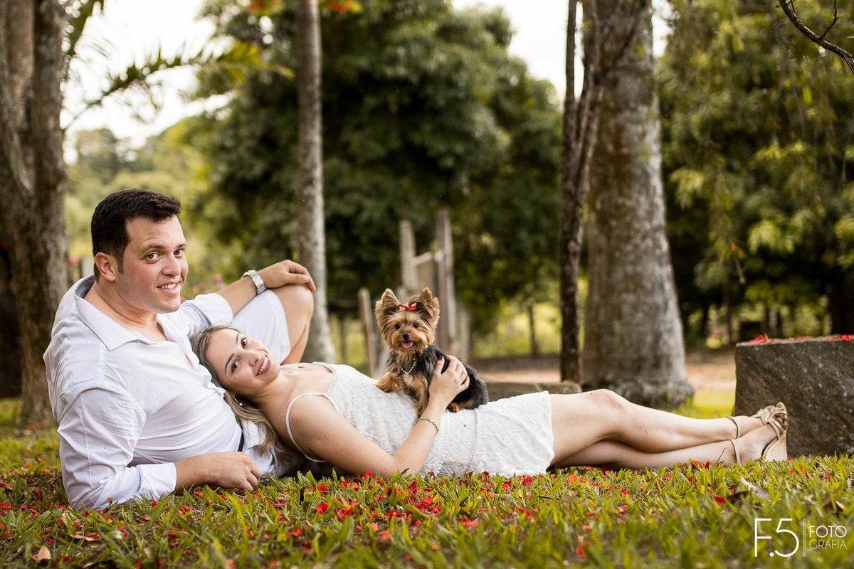 Casal de noivos, Lívia e Renato, deitados no jardim junto ao seu pet,Pré Wedding em Muzambinho- MG.