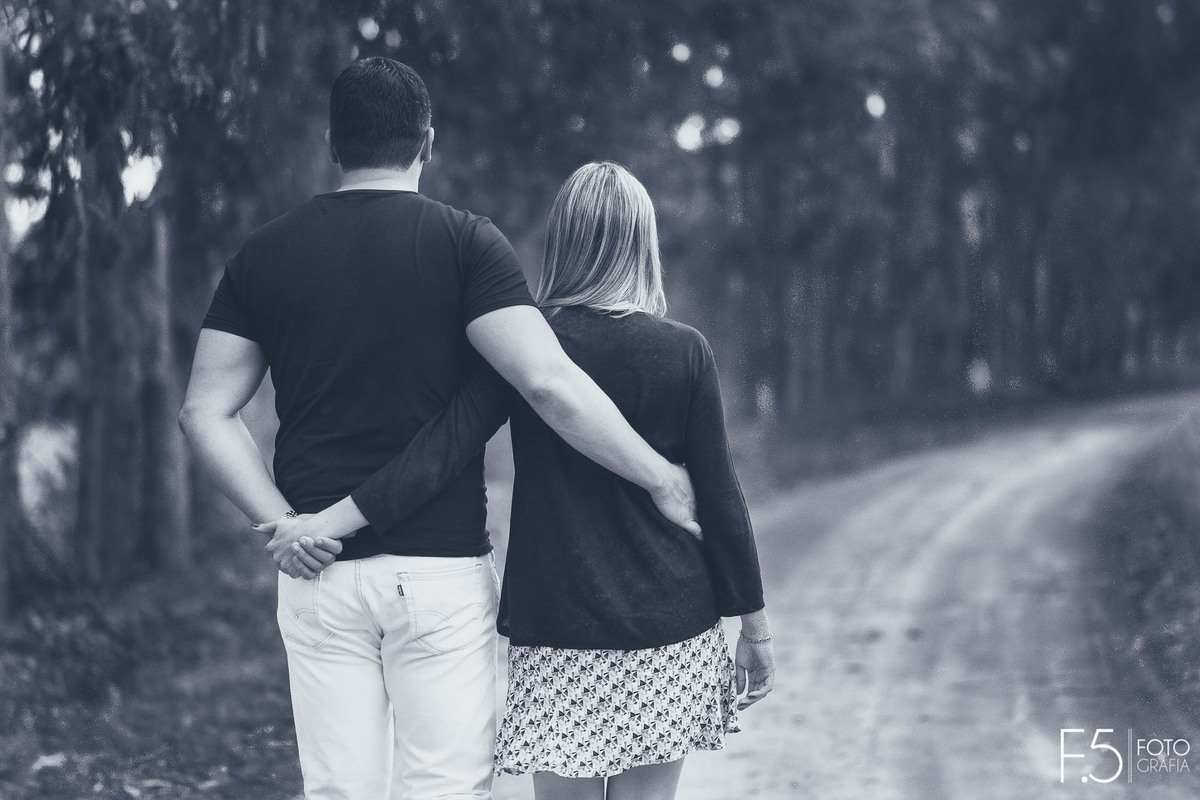 Casal de noivos, Lívia e Renato, caminhando abraçados em uma estrada, Pré Wedding em Muzambinho - MG.