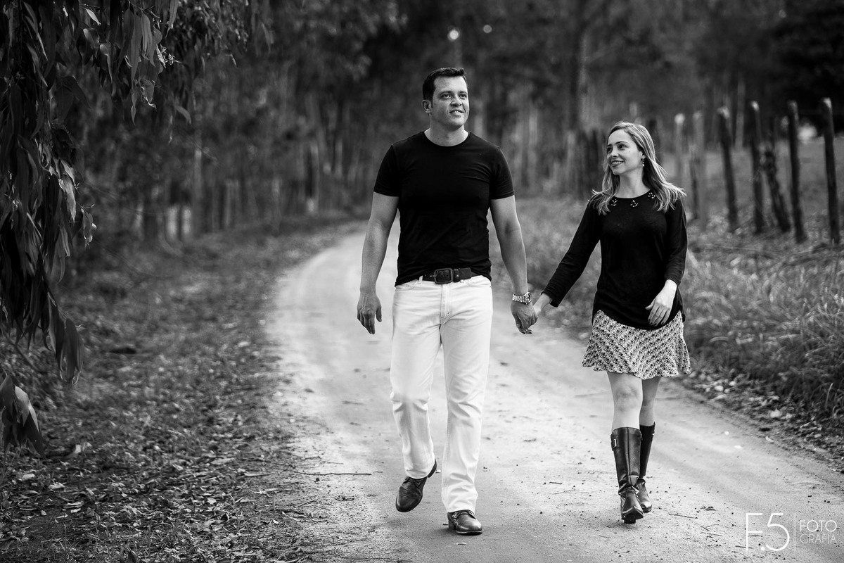 Casal de noivos, Lívia e Renato, caminhando de mãos dadas em uma estrada, Pré Wedding em Muzambinho - MG.