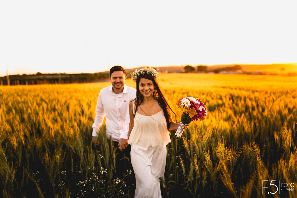 Noiva segurando mão do noivo, por do sol, pré wedding, fotografia de casamento