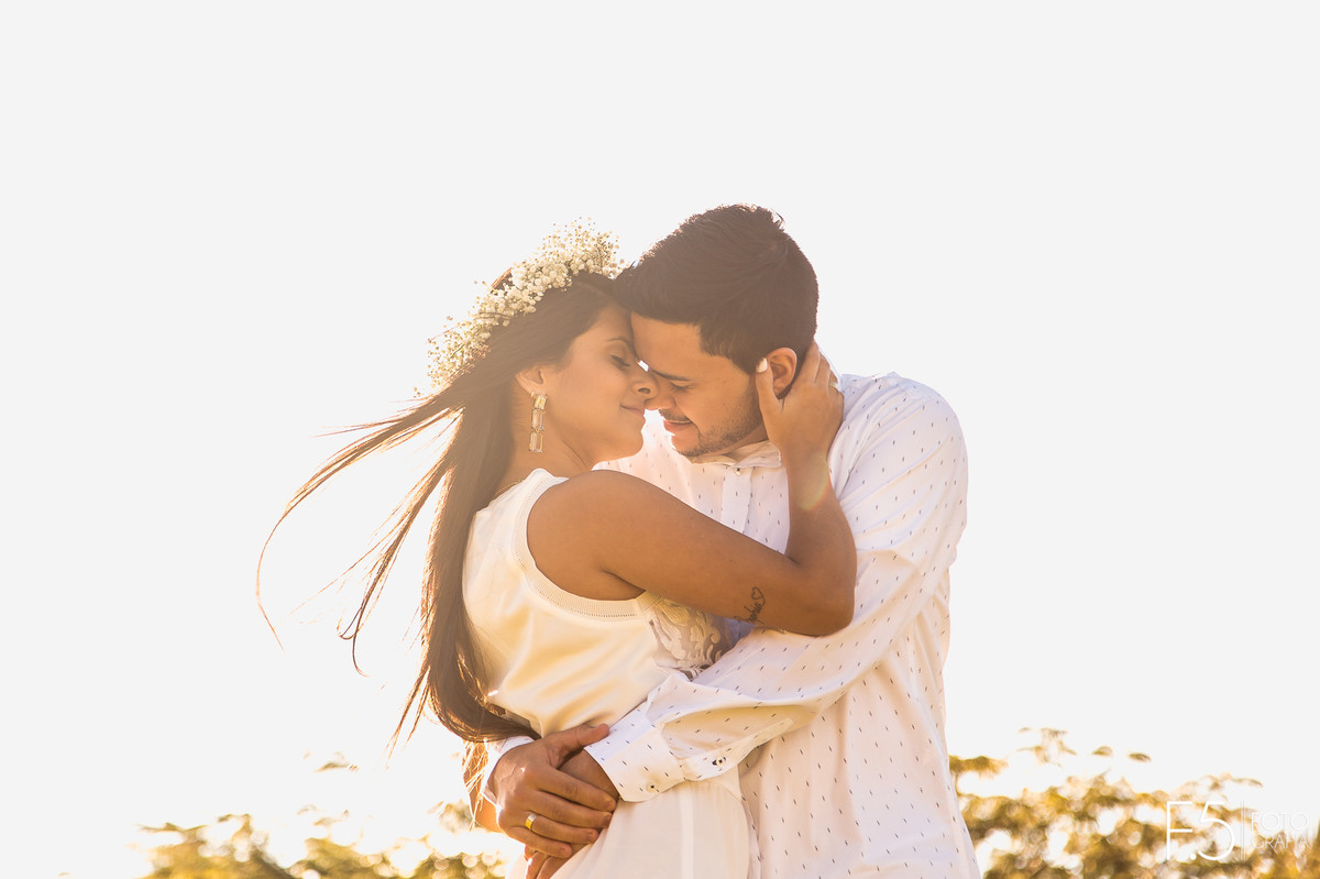 Noivos abraçados, noiva com a mão no rosto do noivo, pré wedding