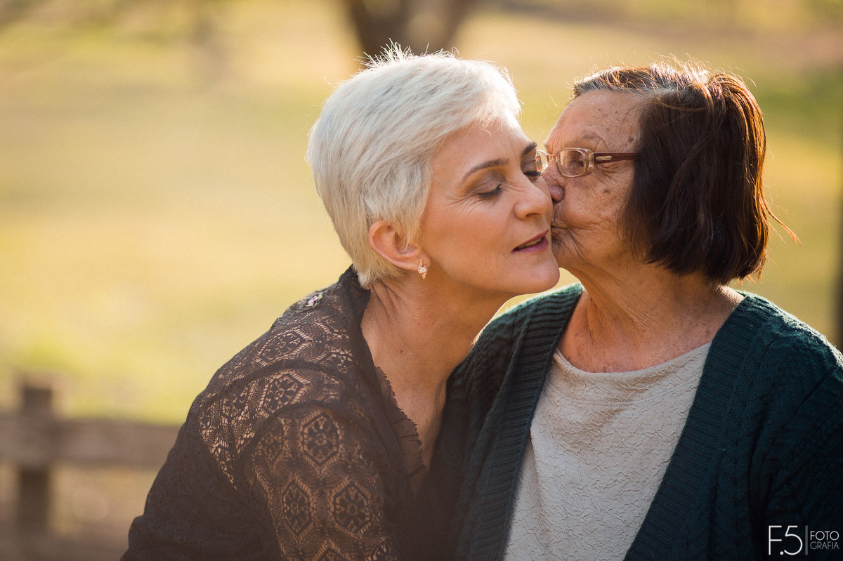 Mãe beijando rosto da filha, fotografia de família