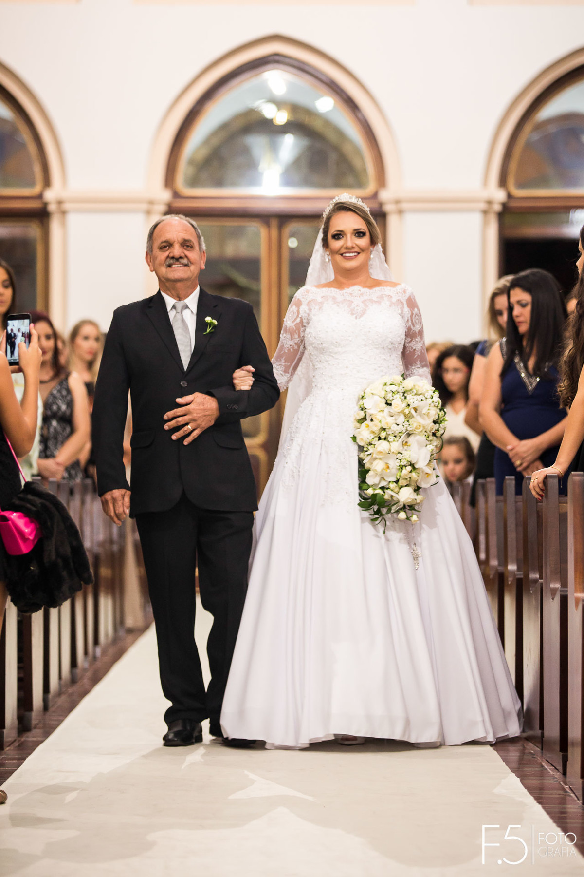 Noiva Maria Alice entrando na Igreja ao lado de seu pai para sua cerimônia que aconteceu em Alfenas - MG.