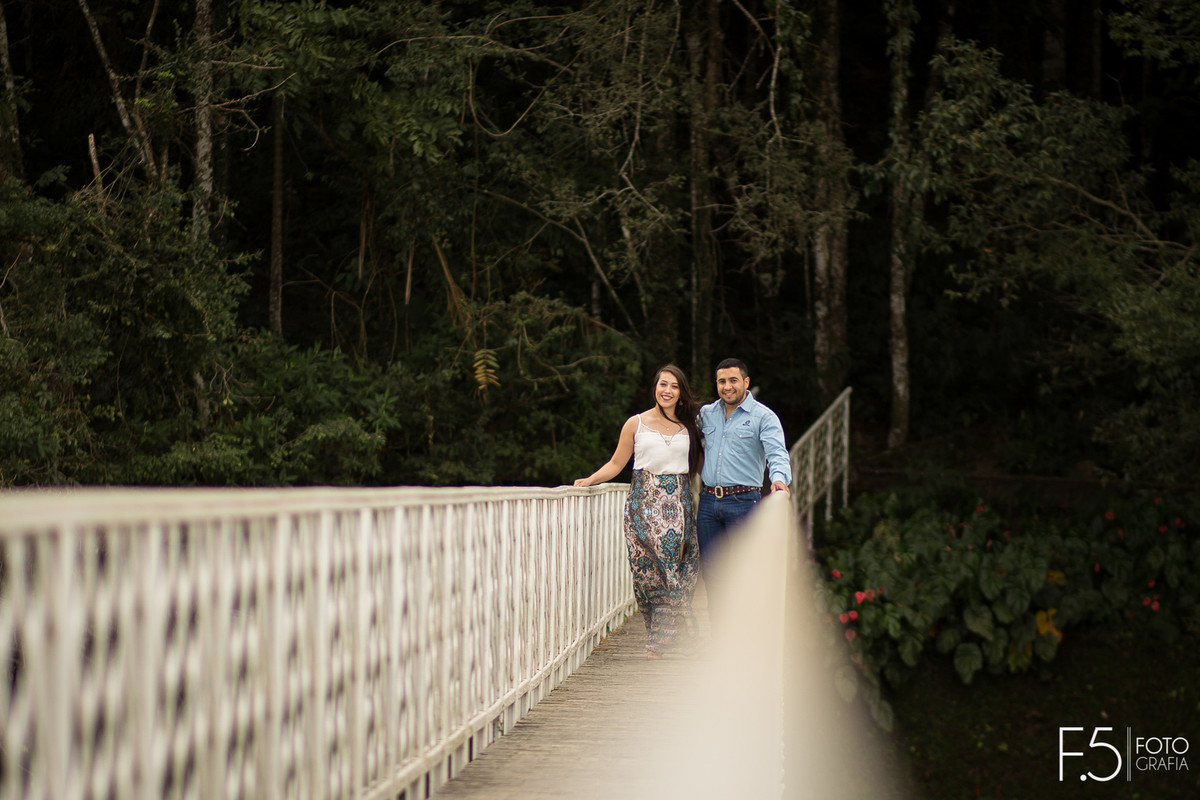 Casal de noivos, Daiane e Charles, sorrindo em meio de uma ponte em uma Fazenda em São Pedro da União - MG.
