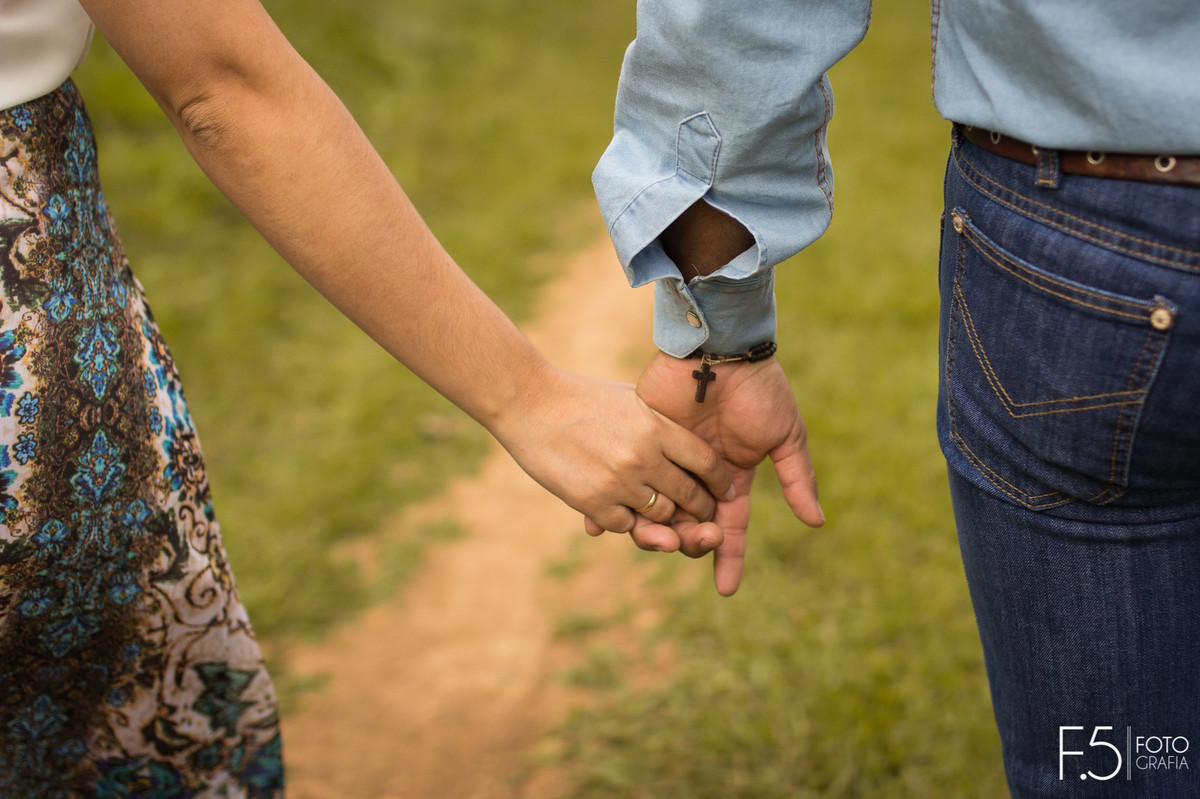 Casal de noivos, Daiane e Charles, caminhando de mãos dadas em uma Fazenda em São Pedro da União - MG.