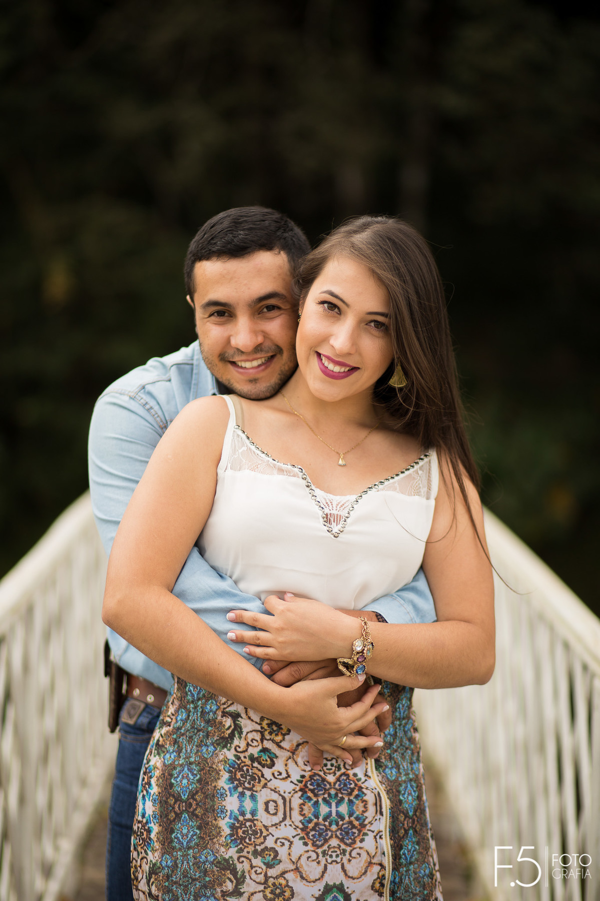 Casal de noivos, Daiane e Charles, sorrindo em meio de uma ponte em uma Fazenda em São Pedro da União - MG.