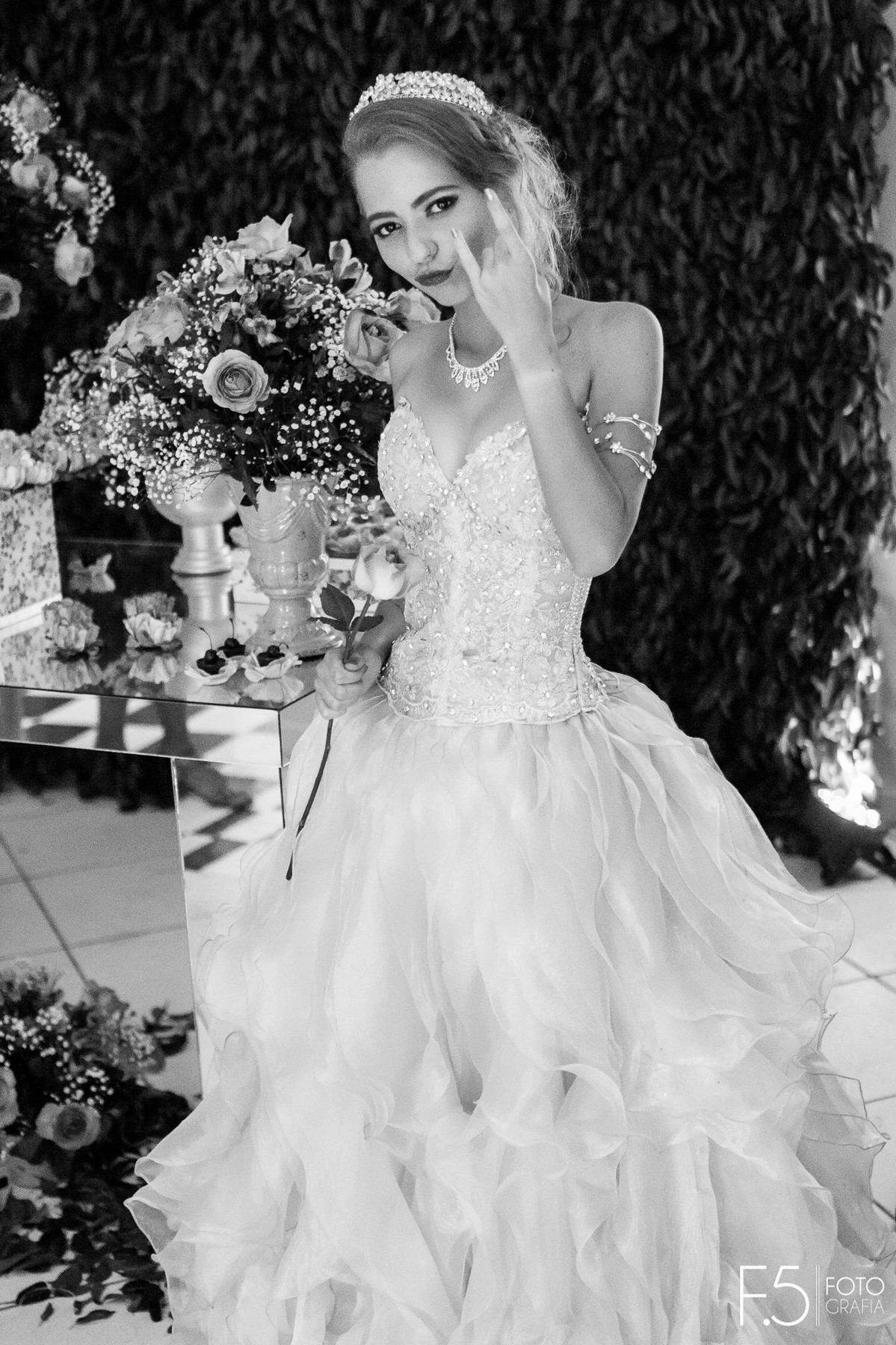 Festa de 15 Anos Amanda, ao lado da mesa decorativa fazendo o sinal do rock, em Muzambinho - MG.