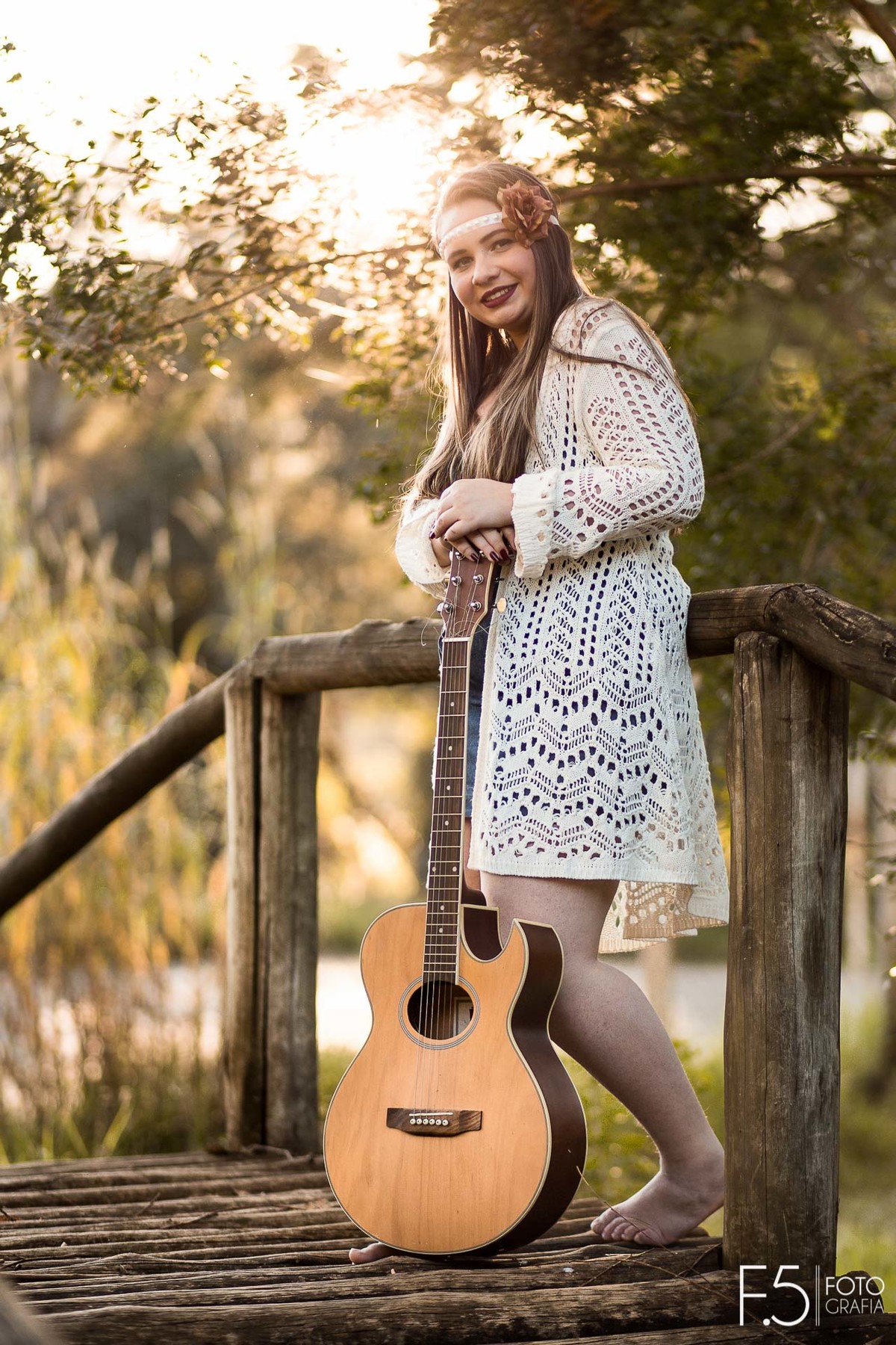 Jade sorrindo em meio a uma ponte, segurando seu violão,  Ensaio Feminino Muzambinho - MG
