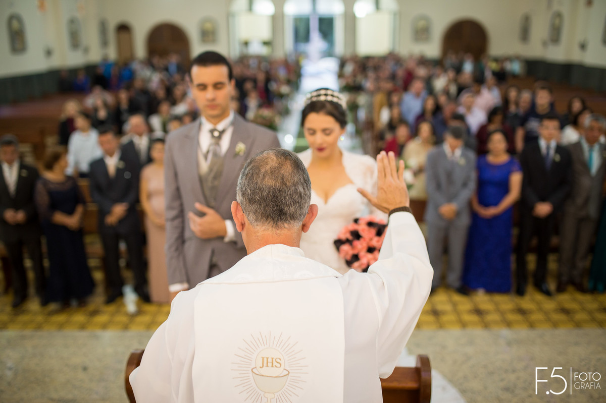 Padre abençoando noivos em meio a cerimônia, Casamento  Muzambinho - MG