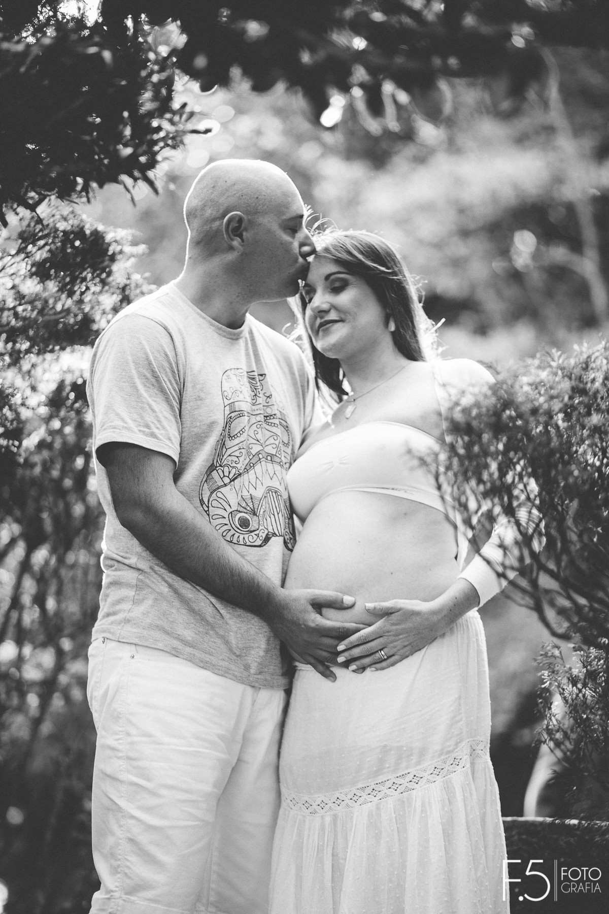 Homem beijando a testa da esposa gestante. Ensaio Gestante Poços de Caldas - MG
