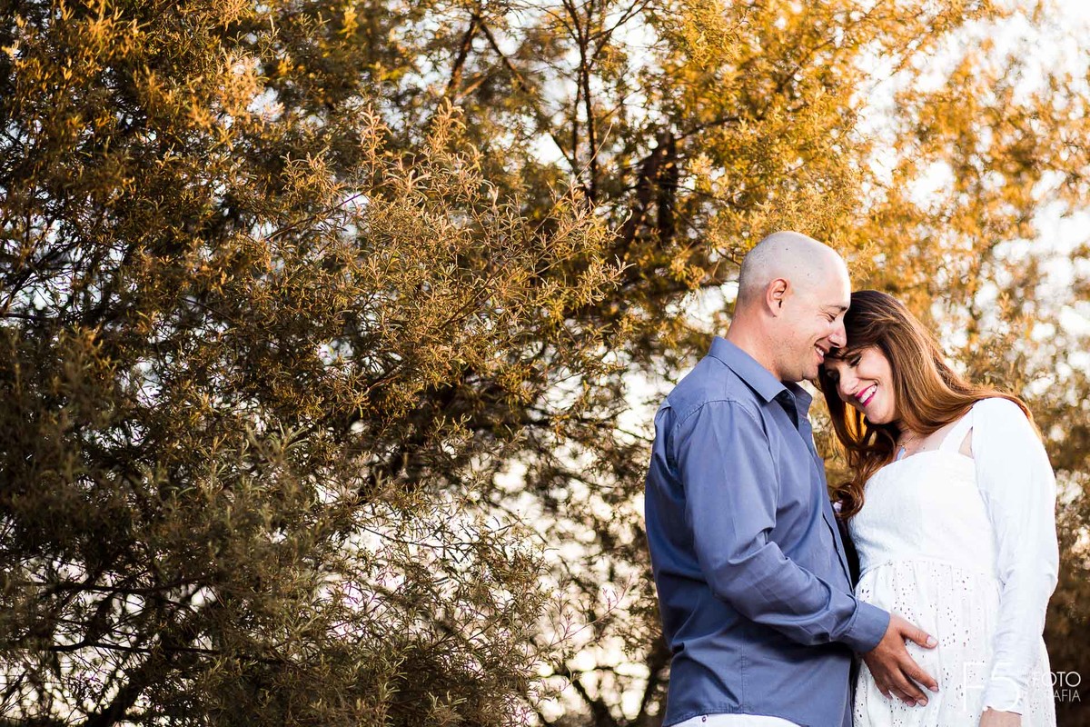 Esposo com a mão na barria da esposa gestante, Ensaio Gestante Poços de Caldas - MG