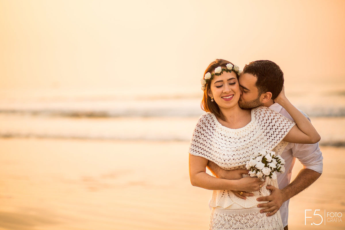 Noivo abraçando noiva Casal de noivos correndo na praia Pré Wedding - Praia Riviera de São Lourenço