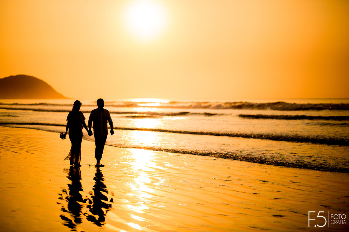 Noivos apreciando o pôr do sol Casal de noivos correndo na praia Pré Wedding - Praia Riviera de São Lourenço