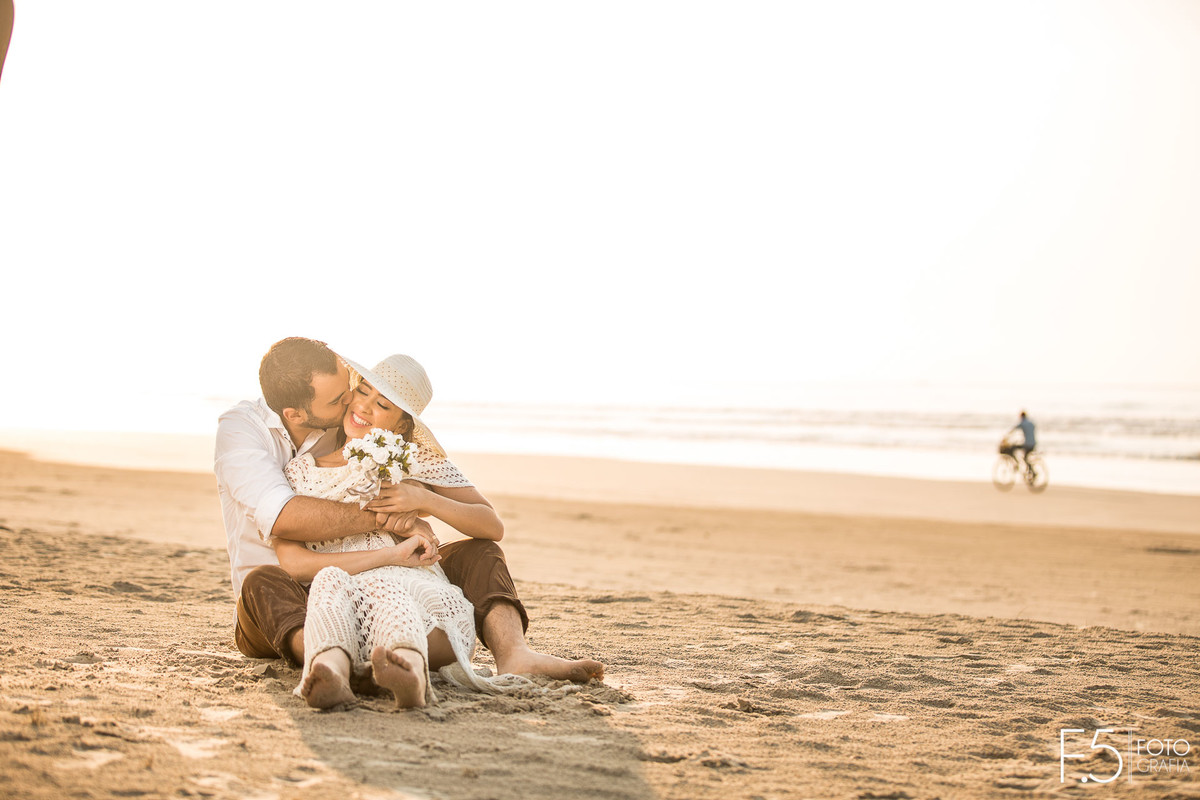 Noivo beijando rosto da noiva Casal de noivos correndo na praia Pré Wedding - Praia Riviera de São Lourenço