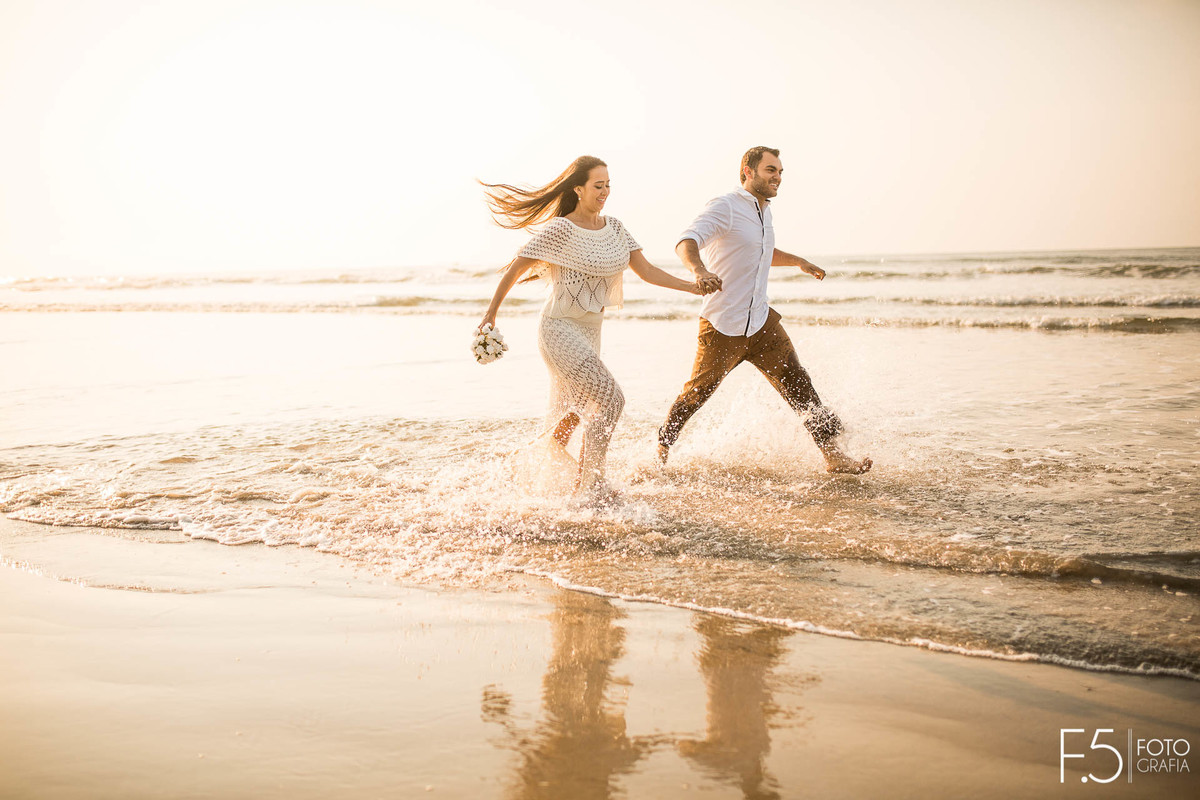 Noivos correndo na praia Casal de noivos correndo na praia Pré Wedding - Praia Riviera de São Lourenço