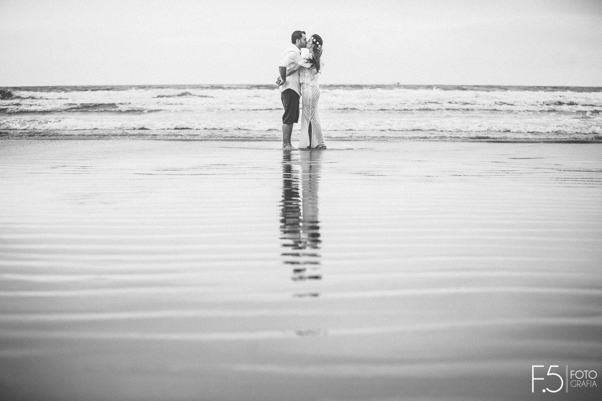 Noivos se beijando a beira mar Casal de noivos correndo na praia Pré Wedding - Praia Riviera de São Lourenço