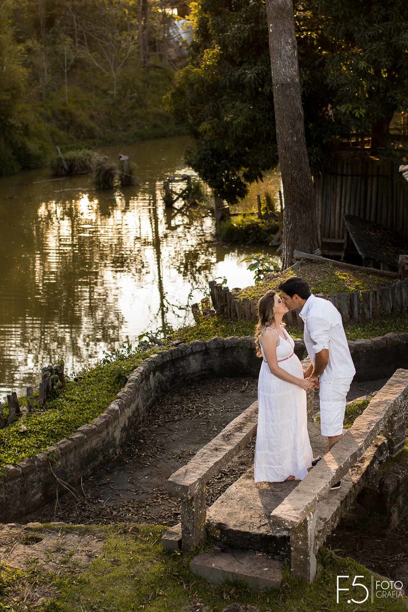 Gestante Gabriela e Eduardo, se beijando em meio a um lago de uma fazenda em Cabo Verde- MG.