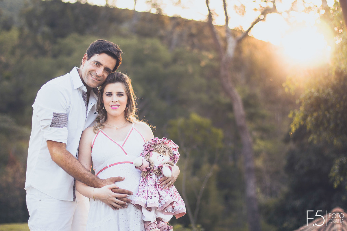 Gabriela e Eduardo, abraçados e junto, a boneca da futura filha, em Cabo Verde - MG.