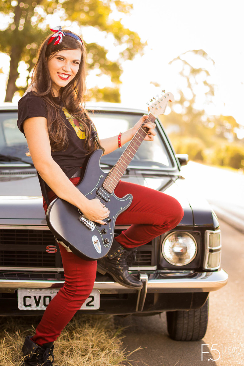 Bruna, segurando sua guitarra em frente ao opala, em Muzambinho - MG.