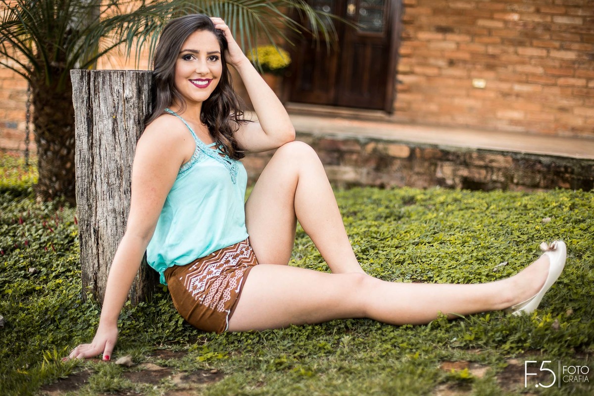 Jéssica, sentada em um Jardim com as mãos na cabeça, em Muzambinho - MG.