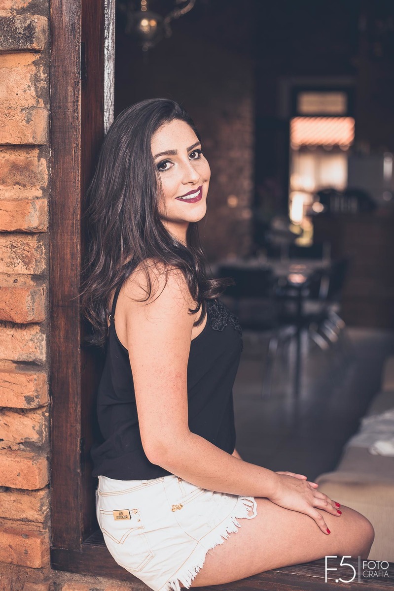 Jéssica, sentada na janela, em Muzambinho - MG.