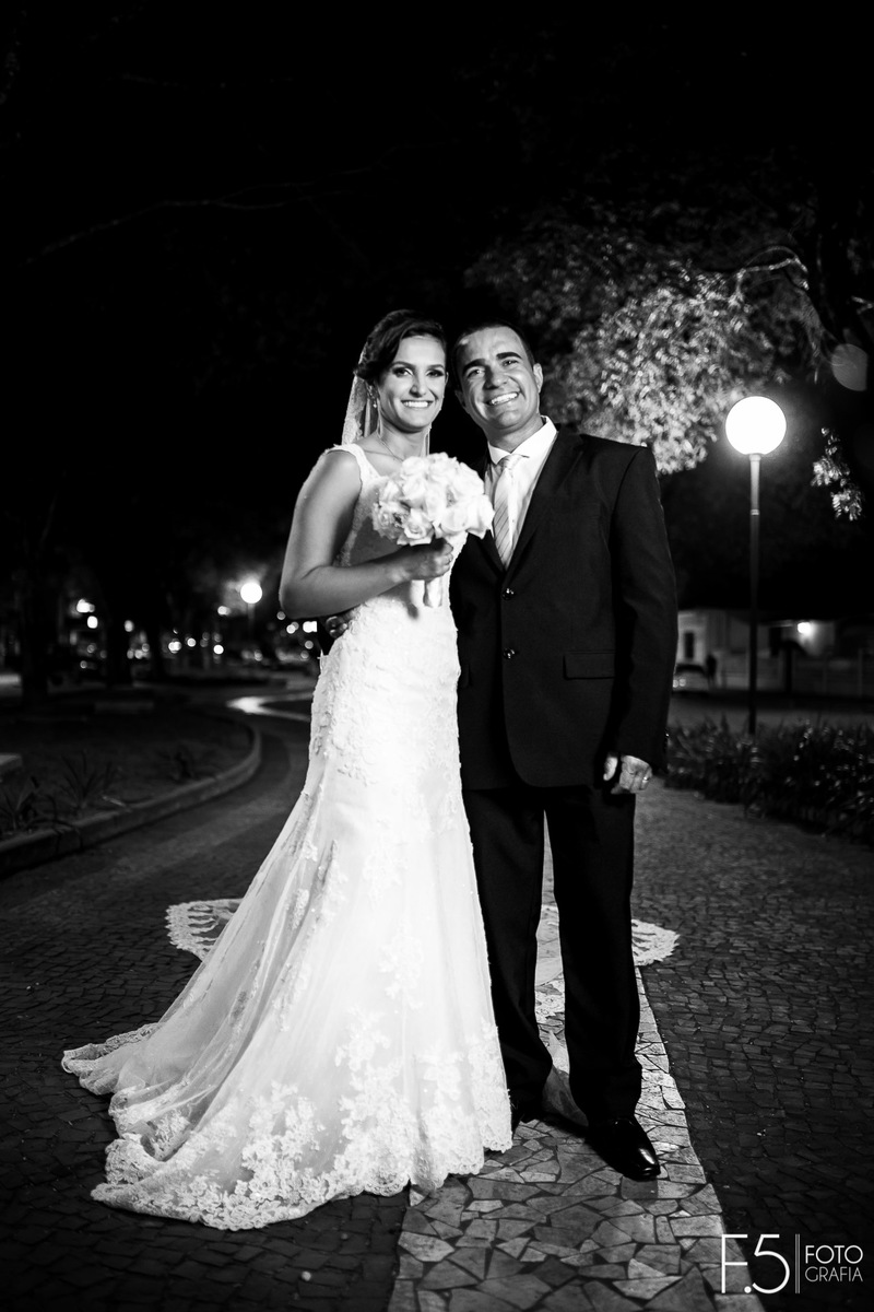 Marcia e Renato, sorrindo em meio a um jardim após a cerimônia, em Muzambinho - MG.