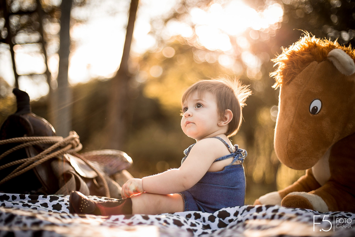 1 ano da Larinha, sentada na toalha olhando para cima, em Muzambinho - MG.