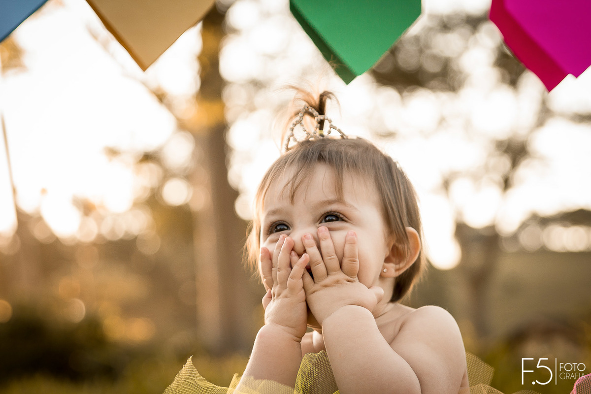 1 ano da Larinha, com a mãozinha no rostinho e olhando para cima, em Muzambinho - MG.