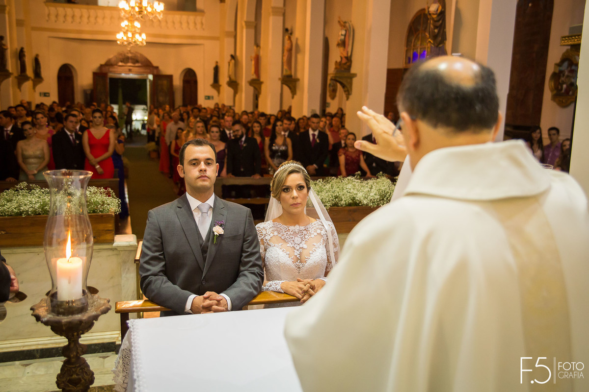 Noivos ajoelhados recebendo a benção, Casamento - Guaranésia MG