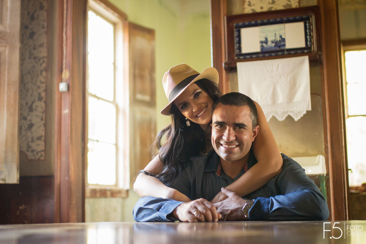 Casal de noivos, Marcia e Renato, abraçando por trás e sorrindo, na Fazenda Santa Gabriela, em Muzambinho - MG.