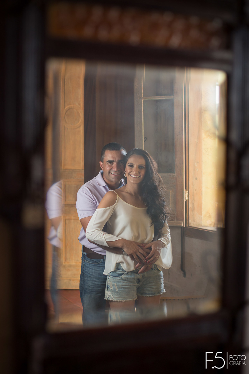 Casal de noivos, Marcia e Renato, sorrindo em frente ao espelho, na Fazenda Santa Gabriela, em Muzambinho - MG.