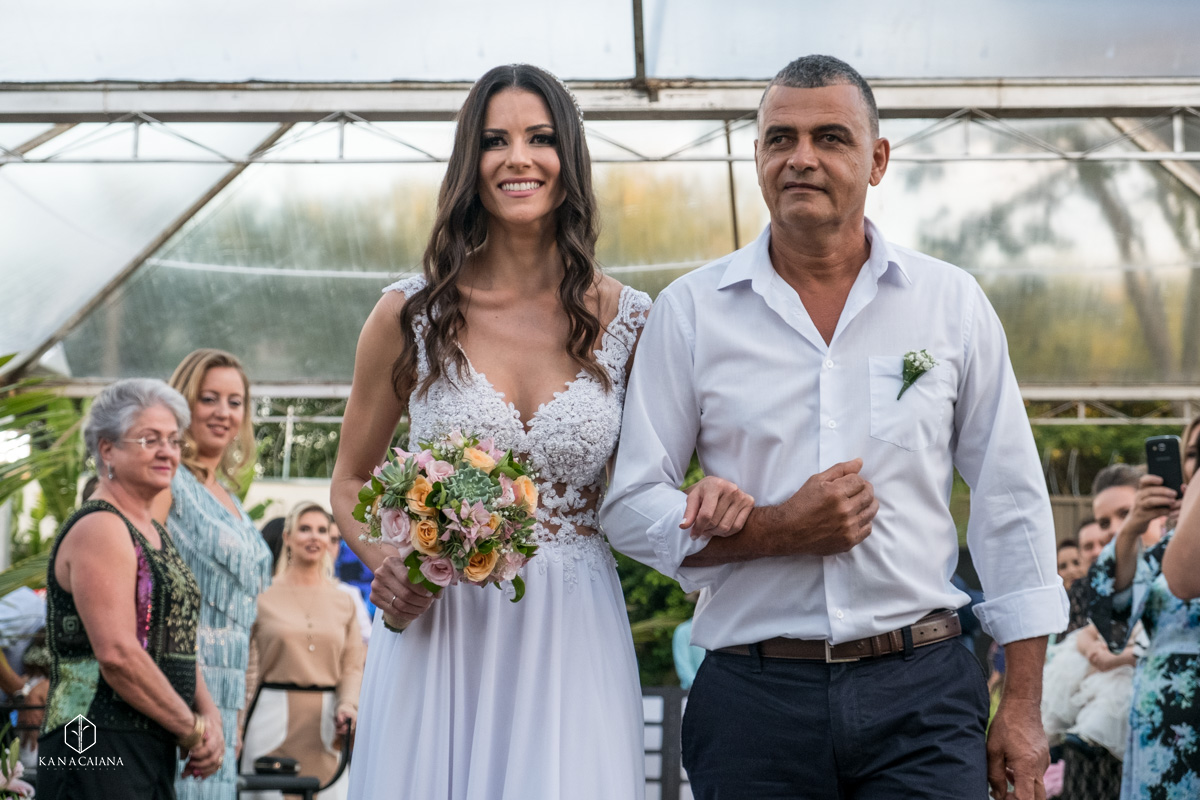 pai emocionado conduz sua filha vestida de noiva até o altar no dia do seu casamento