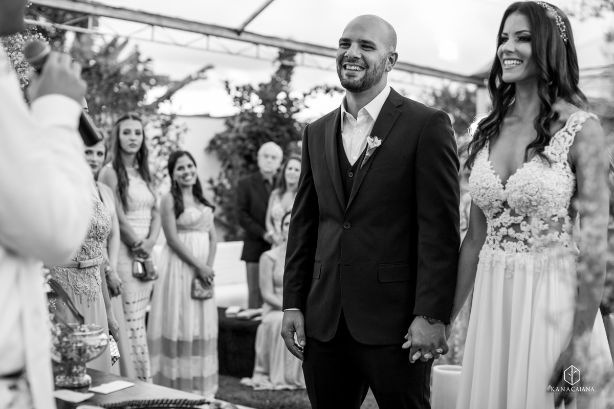 noivo e noiva sorrindo para o celebrante durante cerimônia de casamento no recanto paradise em bauru no interior de são paulo sp