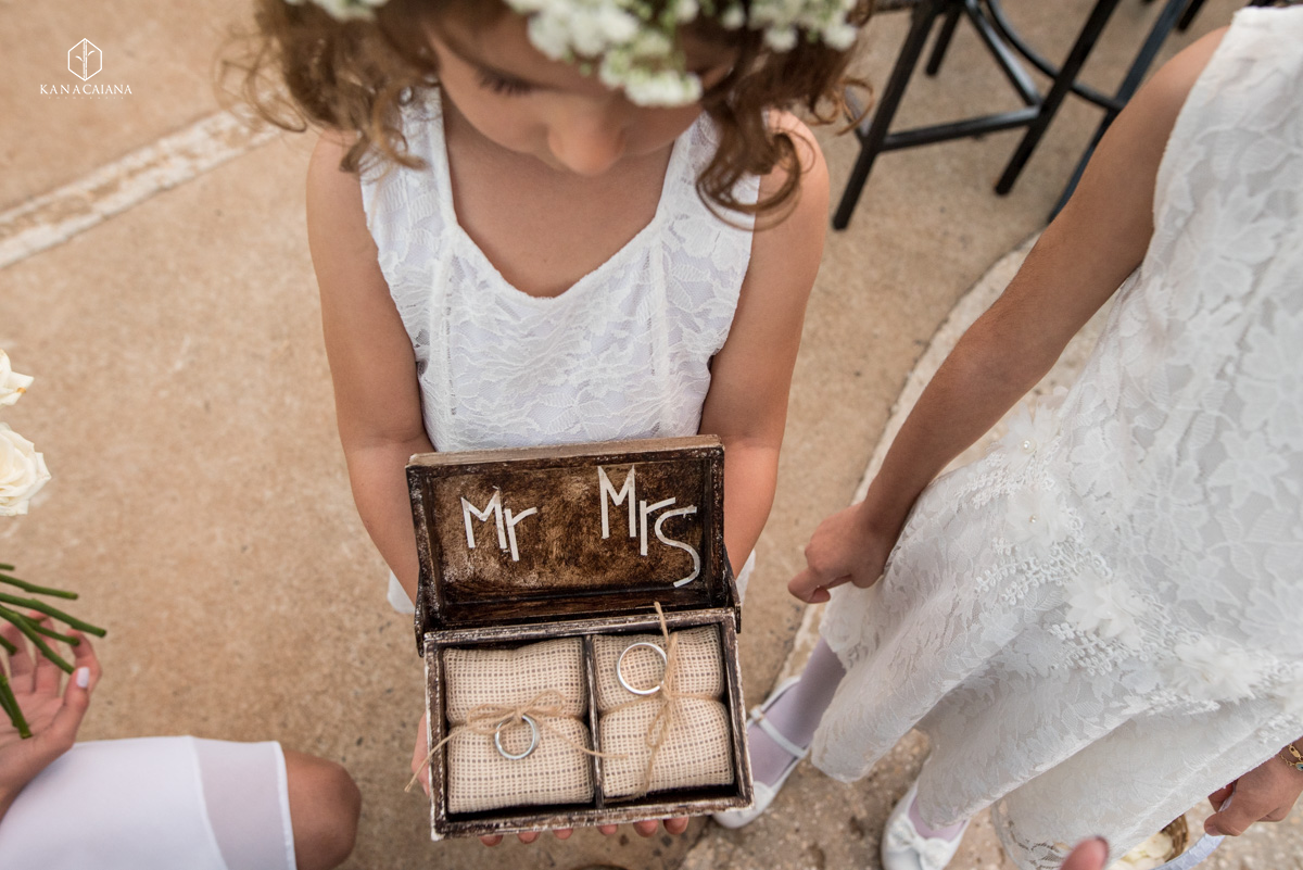daminha fofa conduz as alianças em uma caixinha rústica de madeira durante cerimônia religiosa