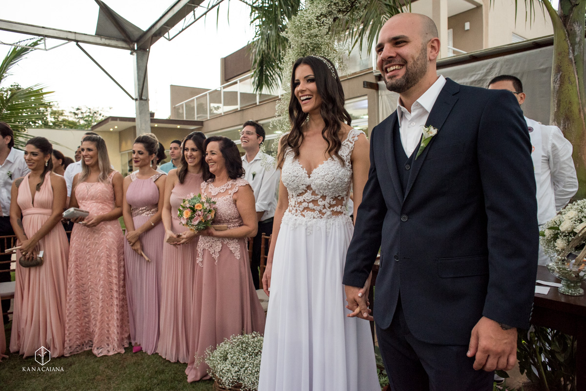 noivos e madrinhas sorrindo enquanto daminhas lindas entram com as alianças durante cerimônia religiosa de seu casamento no recanto paradise em bauru no interior de são paulo sp