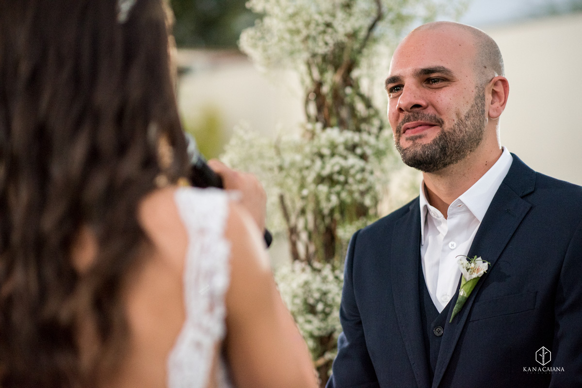 noivo sorrindo para noiva durante cerimônia religiosa em seu casamento