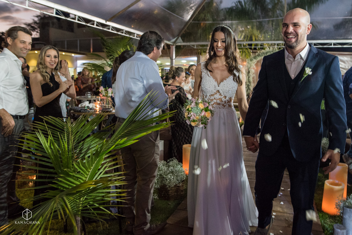 noivos de mãos dadas caminham juntos após cerimônia de casamento