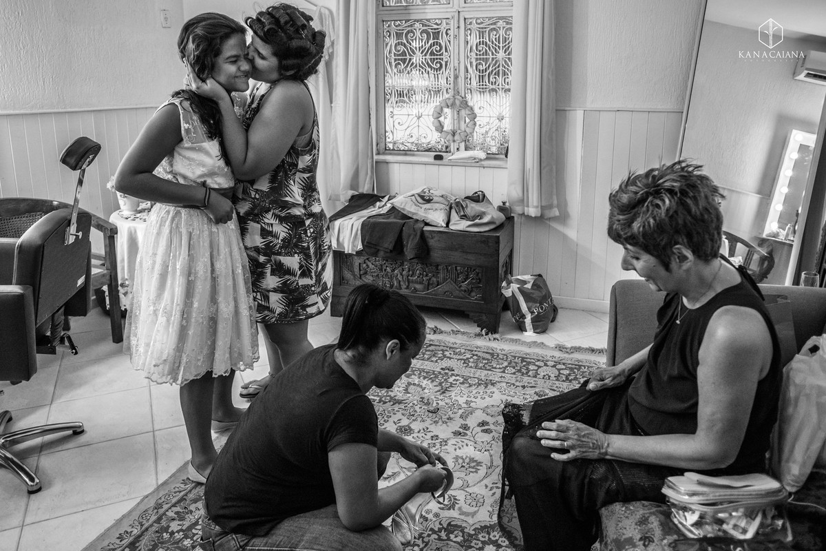 noiva beija daminha enquanto mão calça o sapato durante making of no sítio casuarinas em Vargem Grande no rio de janeiro rj