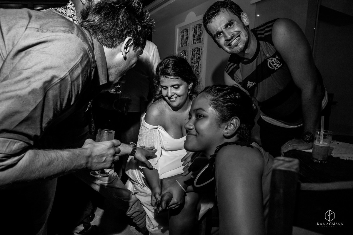 noiva corta o pé enquanto noivo com a camisa do flamengo faz careta durante festa de casamento no sítio casuarinas em Vargem Grande no rio de janeiro rj