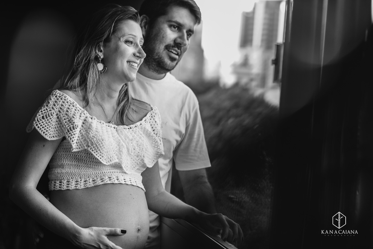 mulher gestante e seu marido observam a vista do seu apartamento durante ensaio de fotos de gestante em São Paulo sp