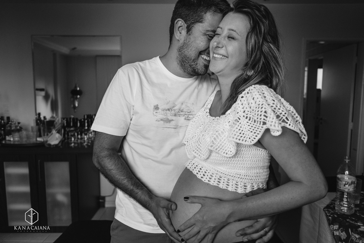 familia feliz sorri e se abraça enquanto esperam a chegada de seu filho durante ensaio de fotos de gestante em São Paulo sp