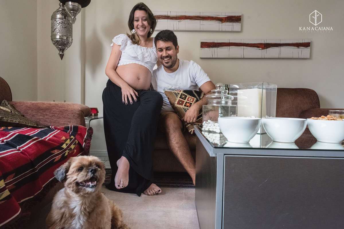 Mulher grávida e seu marido olham para seu cãozinho de estimação e riem durante ensaio de fotos de gestante em São Paulo sp