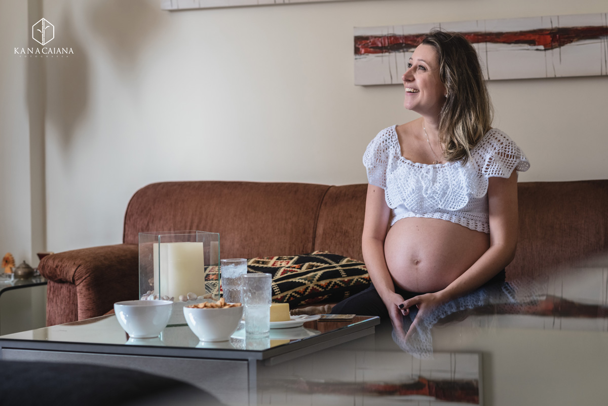 mulher grávida no sofá de casa durante ensaio de fotos de gestante em São Paulo sp