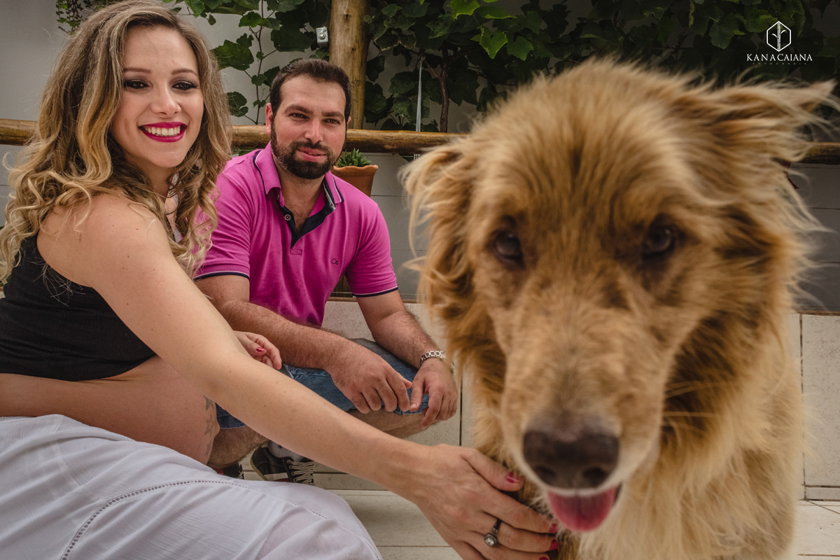 mulher grávida e seu marido brincam com cachorro durante ensaio de fotos de gestante na cidade de lençóis paulista no interior de São Paulo sp