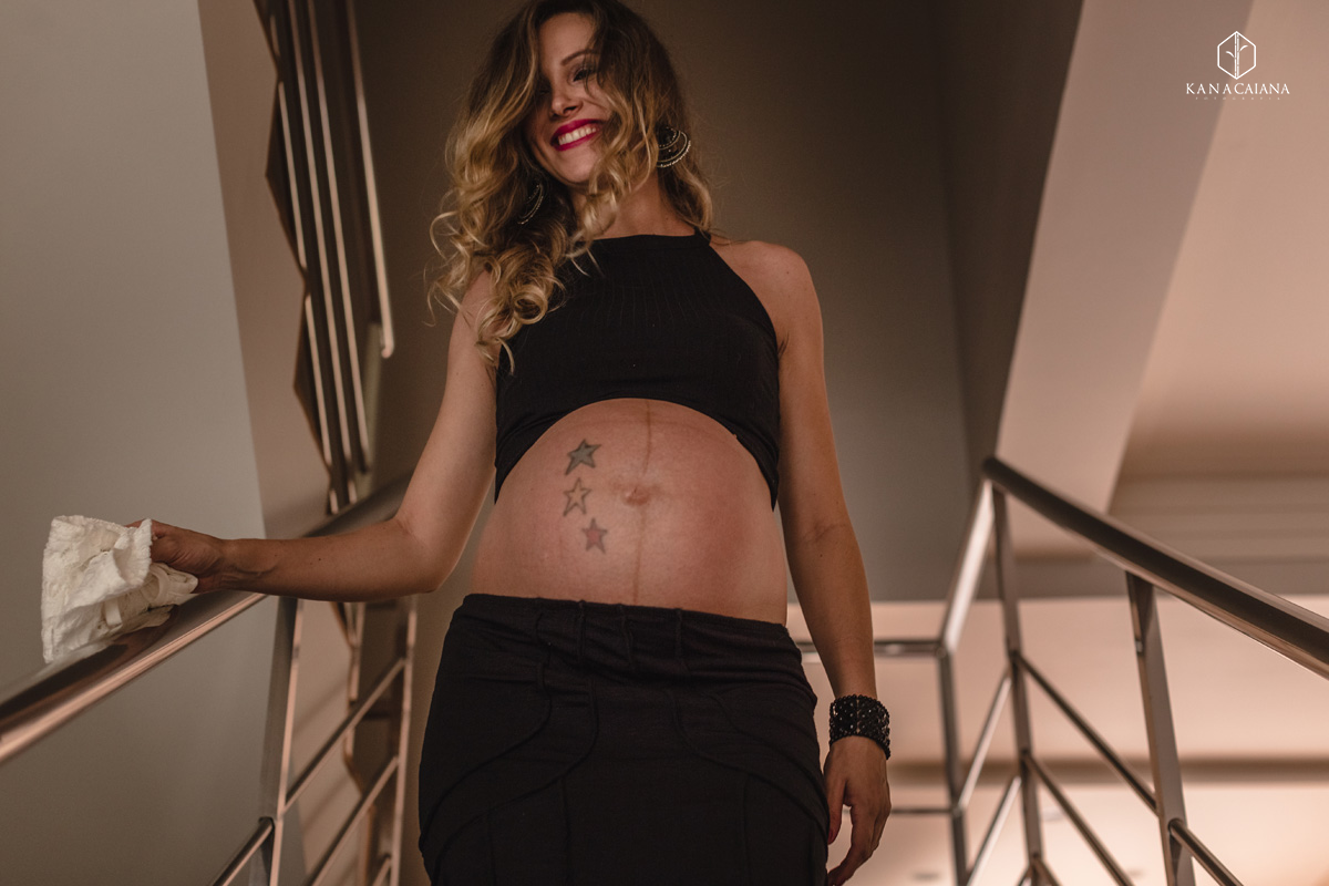 mulher grávida sorri e caminha espontânea durante ensaio de fotos de gestante na cidade de lençóis paulista no interior de São Paulo sp