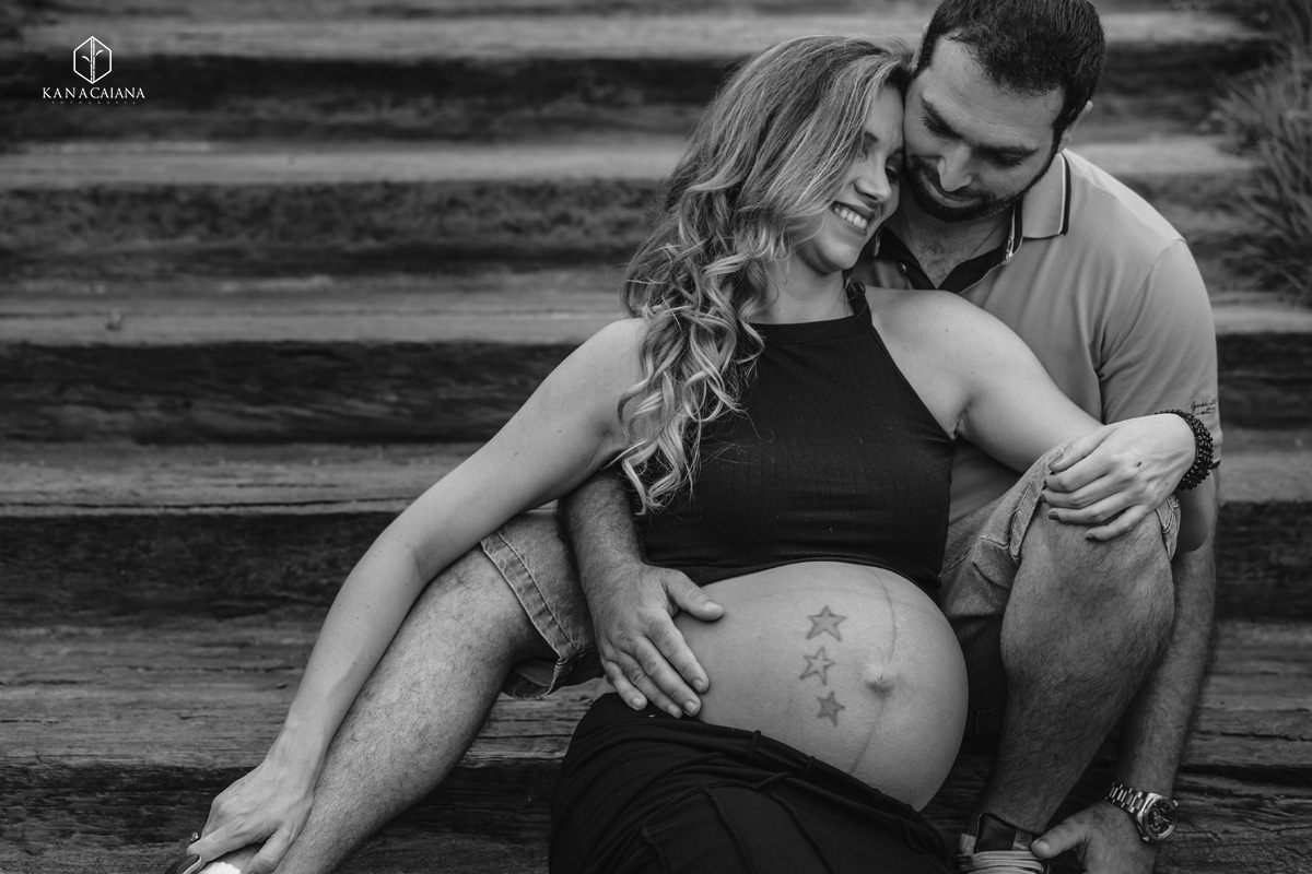 marido abraça no colo sua mulher grávida com muito amor durante ensaio de fotos de gestante na cidade de lençóis paulista no interior de São Paulo sp