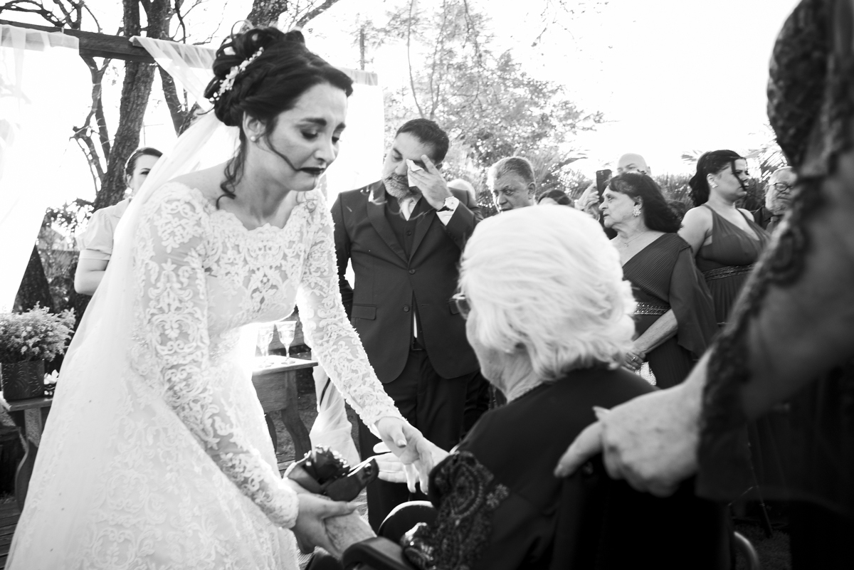 fotografo de casamento em brotas registra momento emocionante durante entrada das alianças em cerimonia de casamento no campo no interior de sao paulo