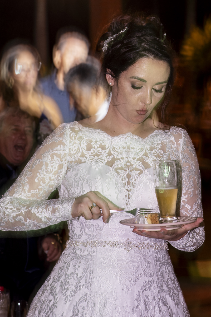 fotografo de casamento em brotas registra momento engraçado de noiva comendo bolo durante festa de casamento no campo