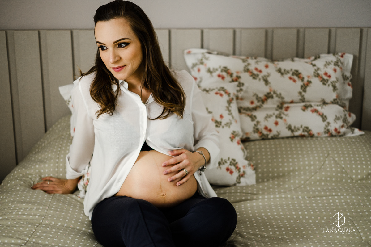 Gestante fazendo carinho na barriga em ensaio de fotos em Itaí, interior de SP