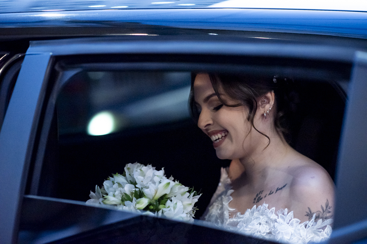 noiva deslumbrante e linda chegando na cerimonia e admirando buque de flores naturais